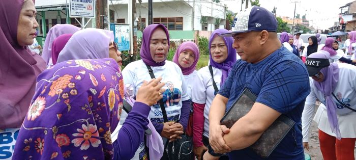 Warga peserta Senam Sehat Pasti Bobby yang diadakan di Jermal 7, berkonsultasi terkait masalah rumah yang ia alami kepada Muhammad Sa’i Rangkuti, SH., MH, Ketua Tim Advokasi Hukum Pasti Bobby Sumut, Minggu pagi, 6 Oktober 2024. (dahsyatnews.com/ist)